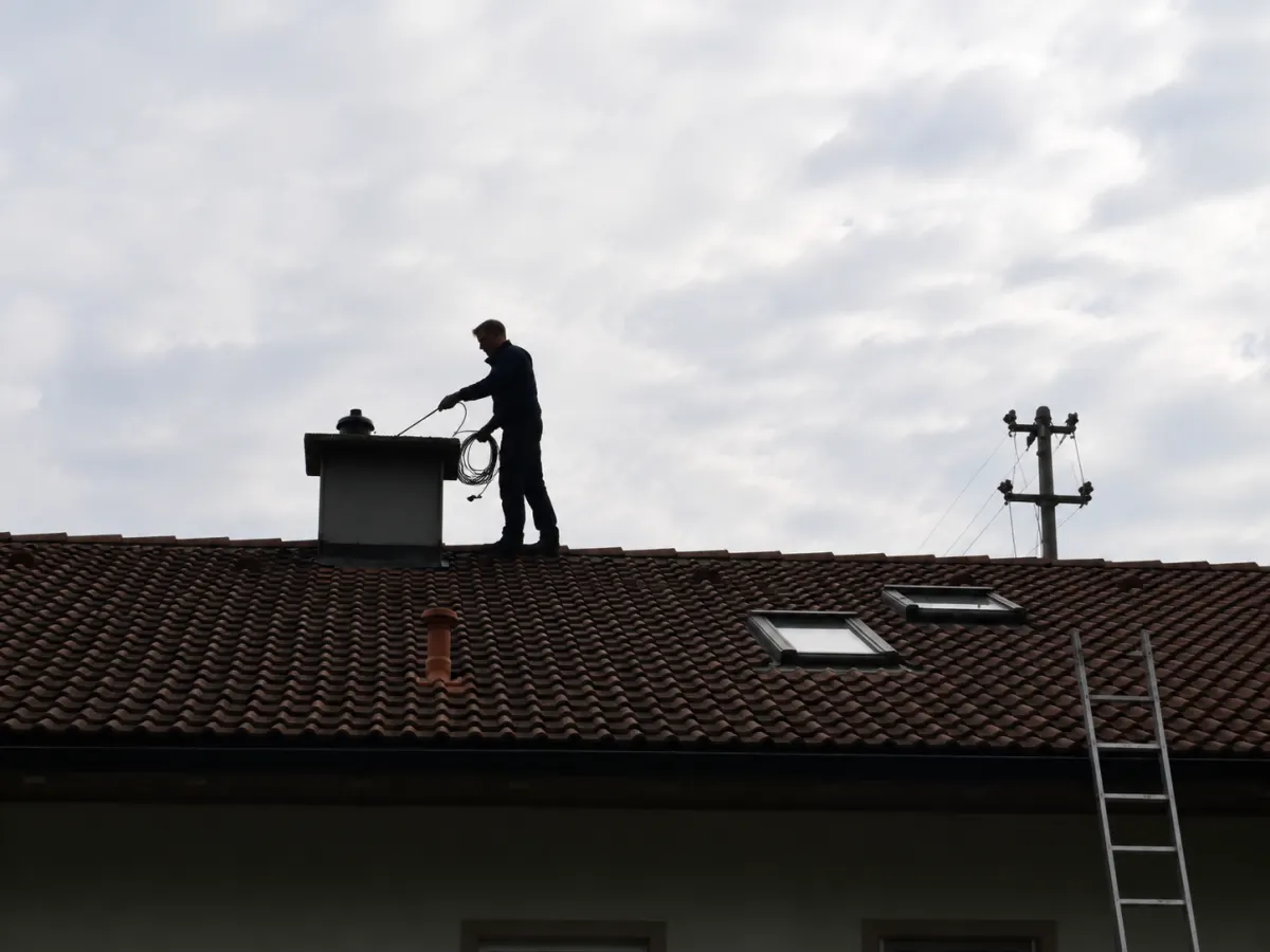 Ramoneur sur un toit au crépuscule